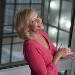 Anita in a pink dress, smiling over her shoulder at the camera