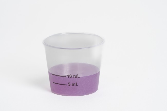 Dosing cup with purple liquid medicine