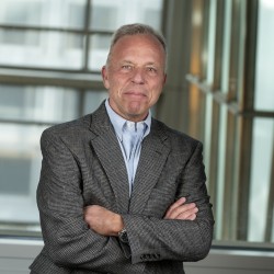 John Troup in a sport coat with arms crossed