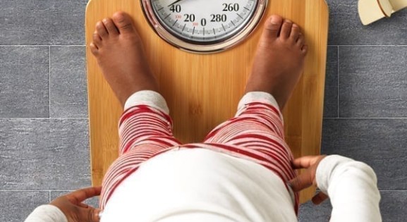 black toddler standing on an analog scale